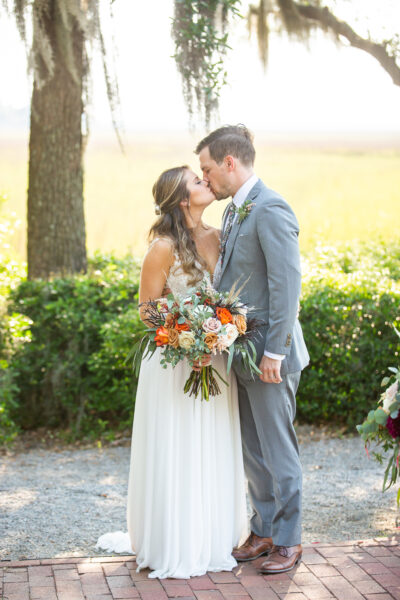 Bride and groom share a tender moment outdoors on their wedding day.