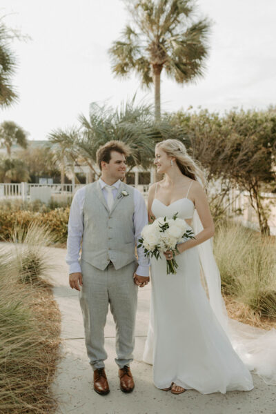Bride and groom walking outdoors on their wedding day.