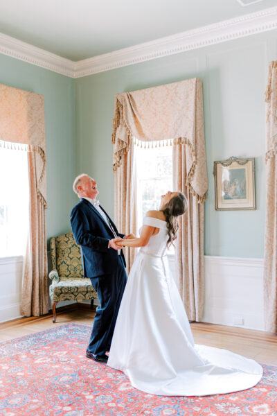 Bride and groom laughing joyfully in an elegant room.