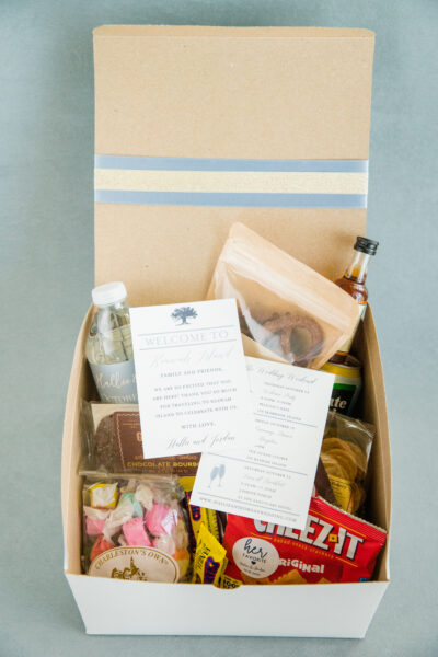 A curated gift box with snacks, drinks, and a handwritten note.