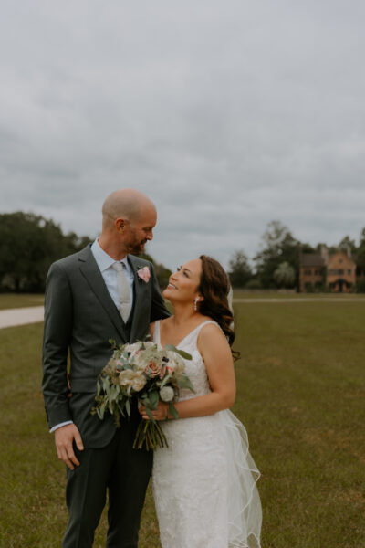 A bride and groom sharing a joyful moment outdoors on their wedding day.