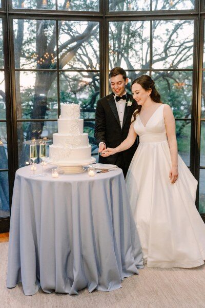 Bride and groom cutting a multi-tiered wedding cake.