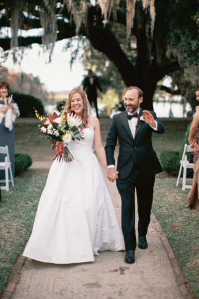 Bride and groom joyfully walk down the aisle after their wedding ceremony.
