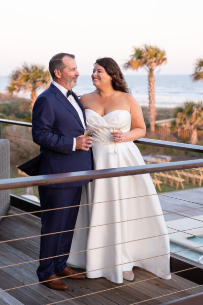 Newlywed couple sharing a joyful moment outdoors at sunset.