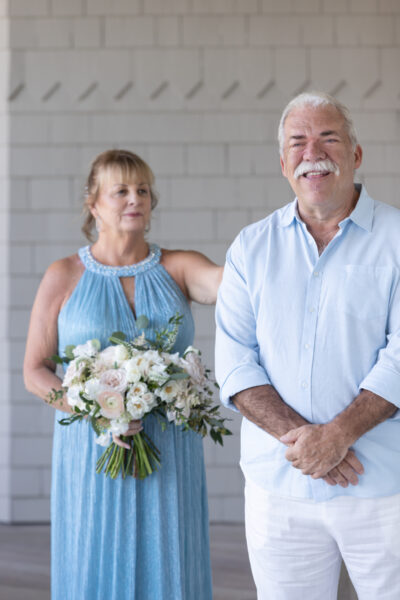 Smiling elderly couple with a bouquet, sharing a joyful moment.