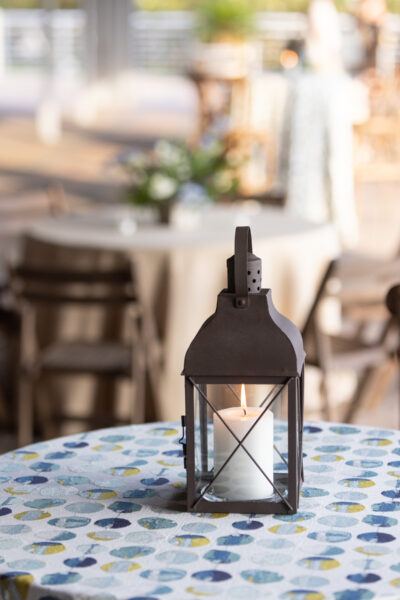 Rustic lantern on a patterned tablecloth in a cozy cafe.