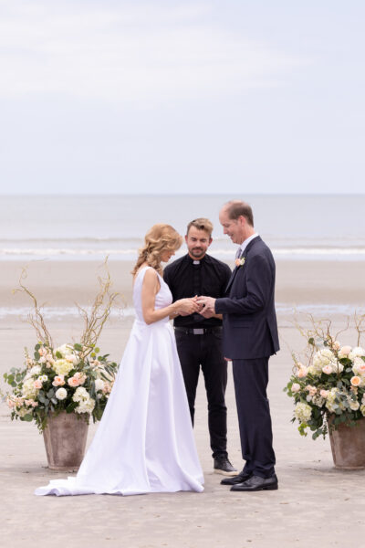 Couple exchanging vows at a serene beach wedding ceremony.