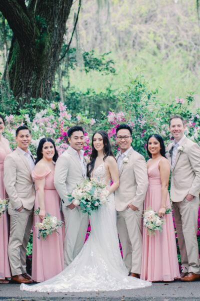 A wedding party posing outdoors with the bride and groom at the center.