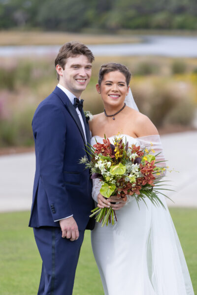 Happy bride and groom posing outdoors on their wedding day.