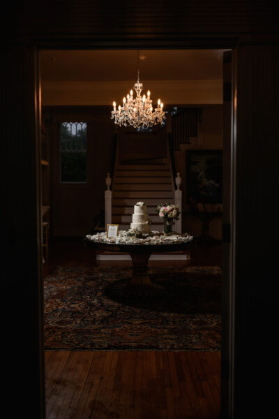 Elegant chandelier-lit entryway with grand staircase and decorative table.