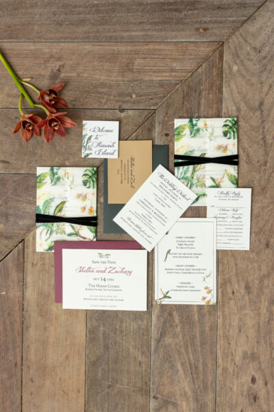 Elegant botanical-themed wedding invitation suite with white and green accents.