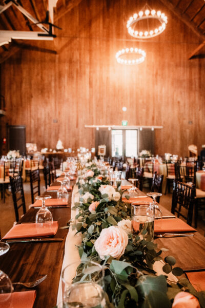Elegant rustic wedding reception with floral centerpiece and wooden decor.