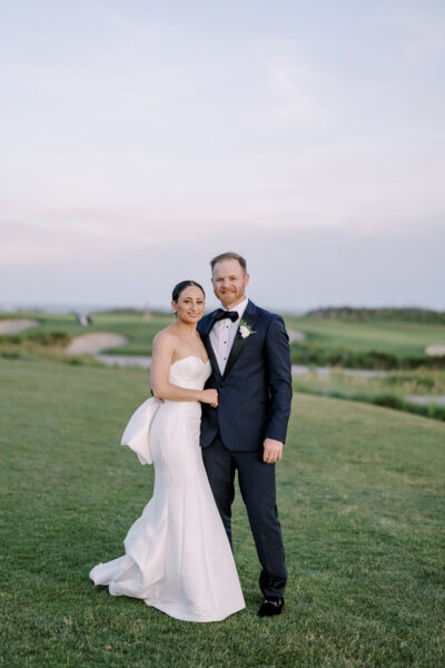 Newlywed couple posing outdoors on their wedding day.