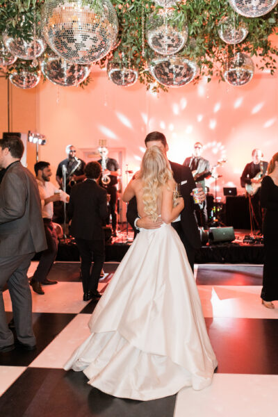 Bride in elegant gown dances at a glamorous wedding reception.