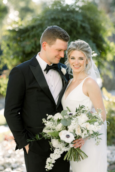 Bride and groom smiling outdoors on their wedding day.