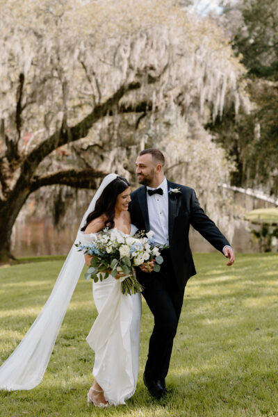 Newlywed couple joyfully walking outdoors after wedding ceremony.