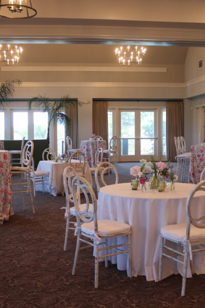 Elegant dining room with round tables and floral chairs.