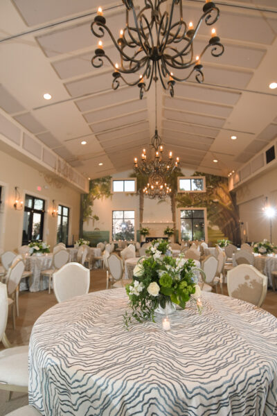 Elegant banquet hall set up for a formal event with floral centerpieces.