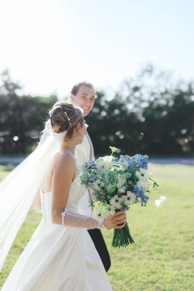 Bride and groom smiling outdoors on their wedding day.