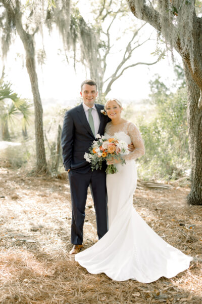 Bride and groom posing outdoors on their wedding day.