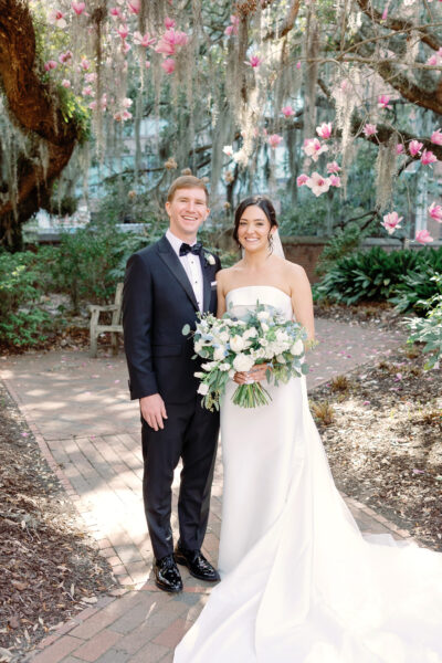 Bride and groom posing outdoors on their wedding day.