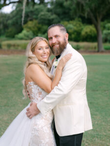 A happy bride and groom embracing outdoors on their wedding day.