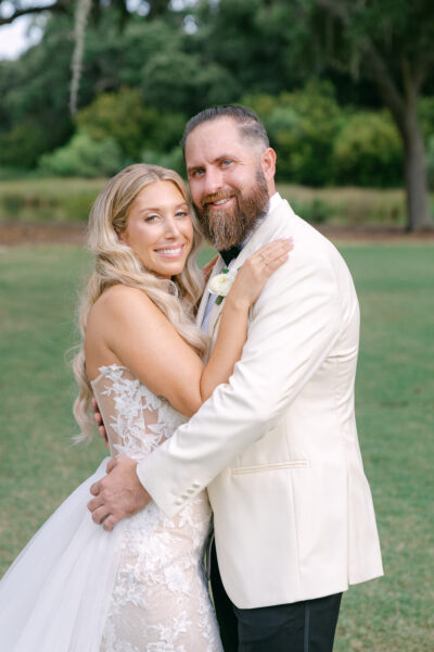A happy bride and groom embracing outdoors on their wedding day.