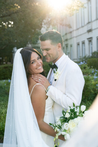 Joyful bride and groom sharing a loving moment outdoors.