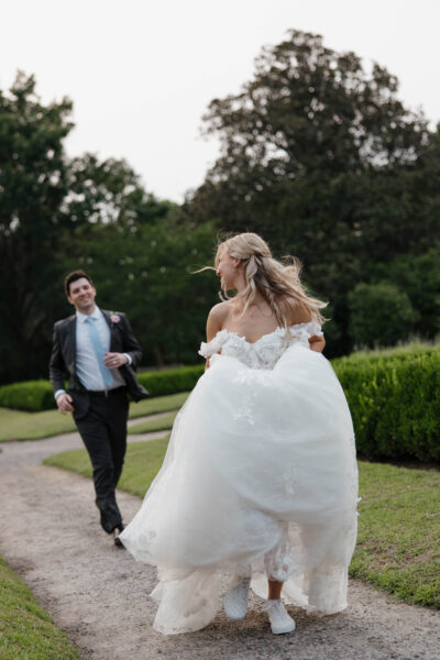Bride joyfully running towards her groom outdoors.